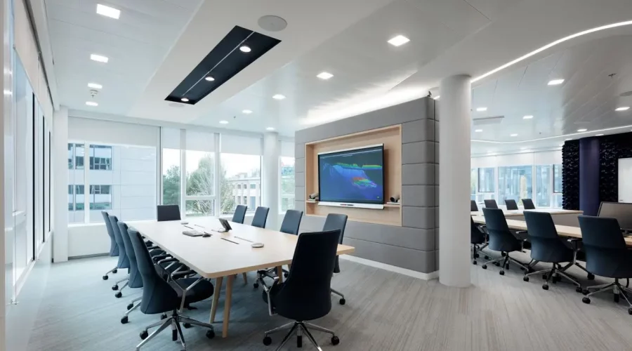 Medientechnik im Konferenzraum mit Präsentationsdisplay und Konferenztisch